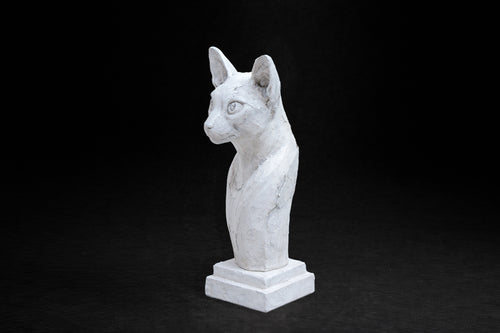 White plaster portrait bust of an Abyssinian cat with large ears on a stepped square base.