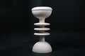 The Annulet barstool in white. The sculptural base rises from a domed foot through three stacked horizontal discs, narrowing to a stem that supports a wide chalice-shaped seat cradle, topped with a round white bouclé upholstered seat.