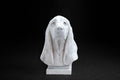 White plaster portrait bust of a Basset Hound with long drooping ears on a stepped square base.