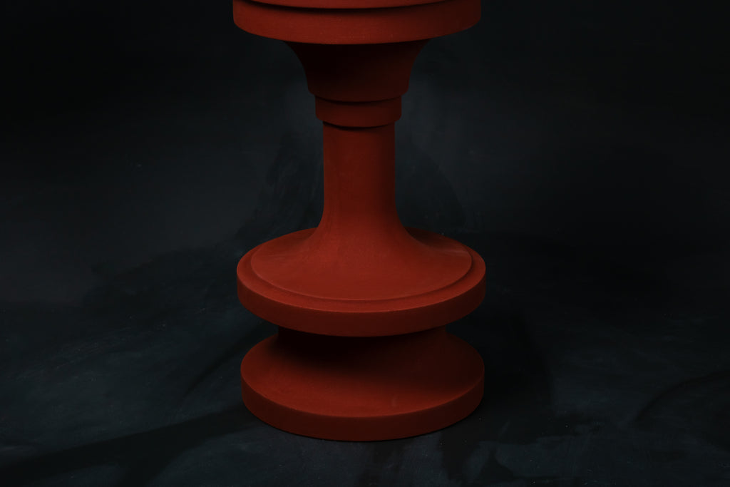 Entasis barstool in terracotta. The pedestal base features layered circular mouldings that taper at the waist, topped with a round white bouclé upholstered seat.