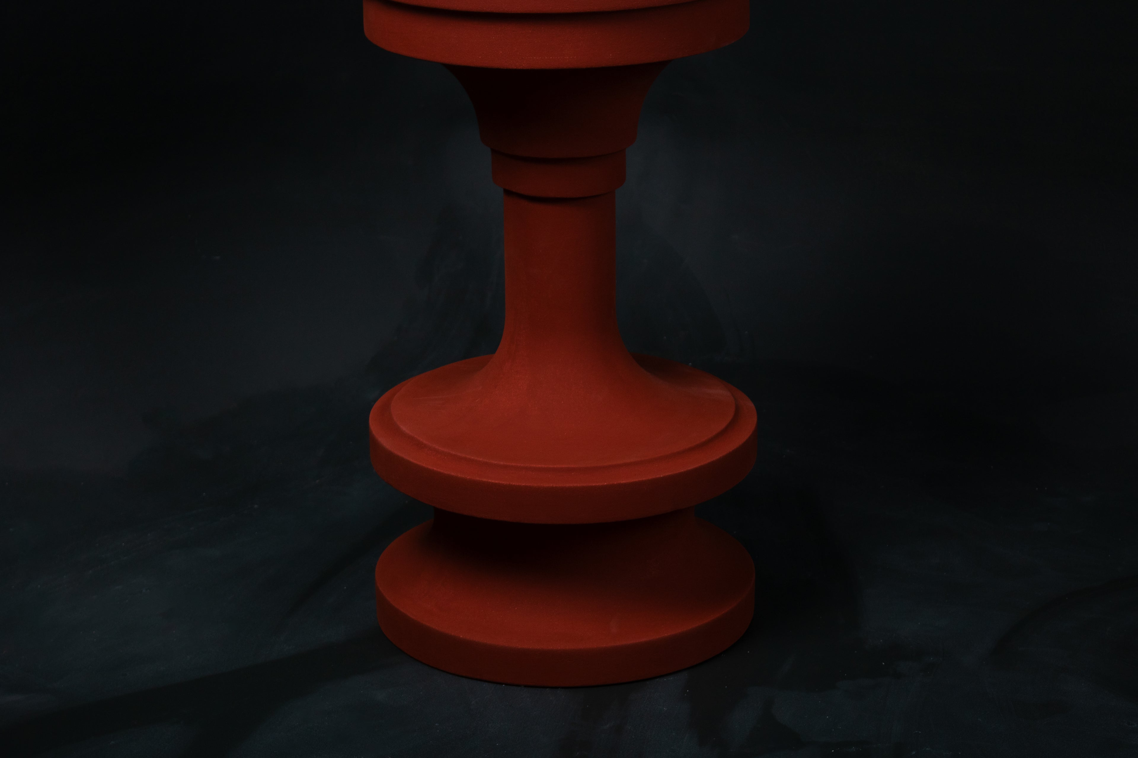 Entasis barstool in terracotta. The pedestal base features layered circular mouldings that taper at the waist, topped with a round white bouclé upholstered seat.