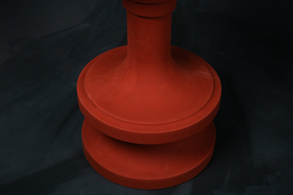 Entasis barstool in terracotta. The pedestal base features layered circular mouldings that taper at the waist, topped with a round white bouclé upholstered seat.
