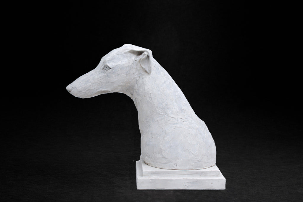 White plaster portrait bust of a Greyhound with a long narrow muzzle on a stepped square base
