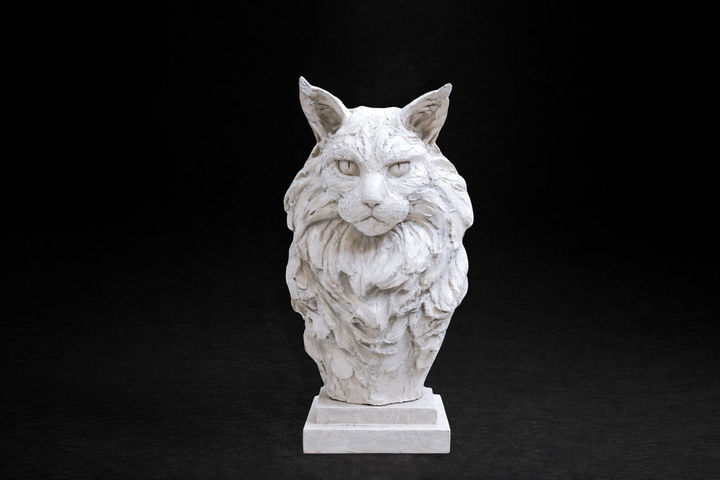 White plaster portrait bust of a Maine Coon cat with a full ruff and tufted ears on a stepped square base.