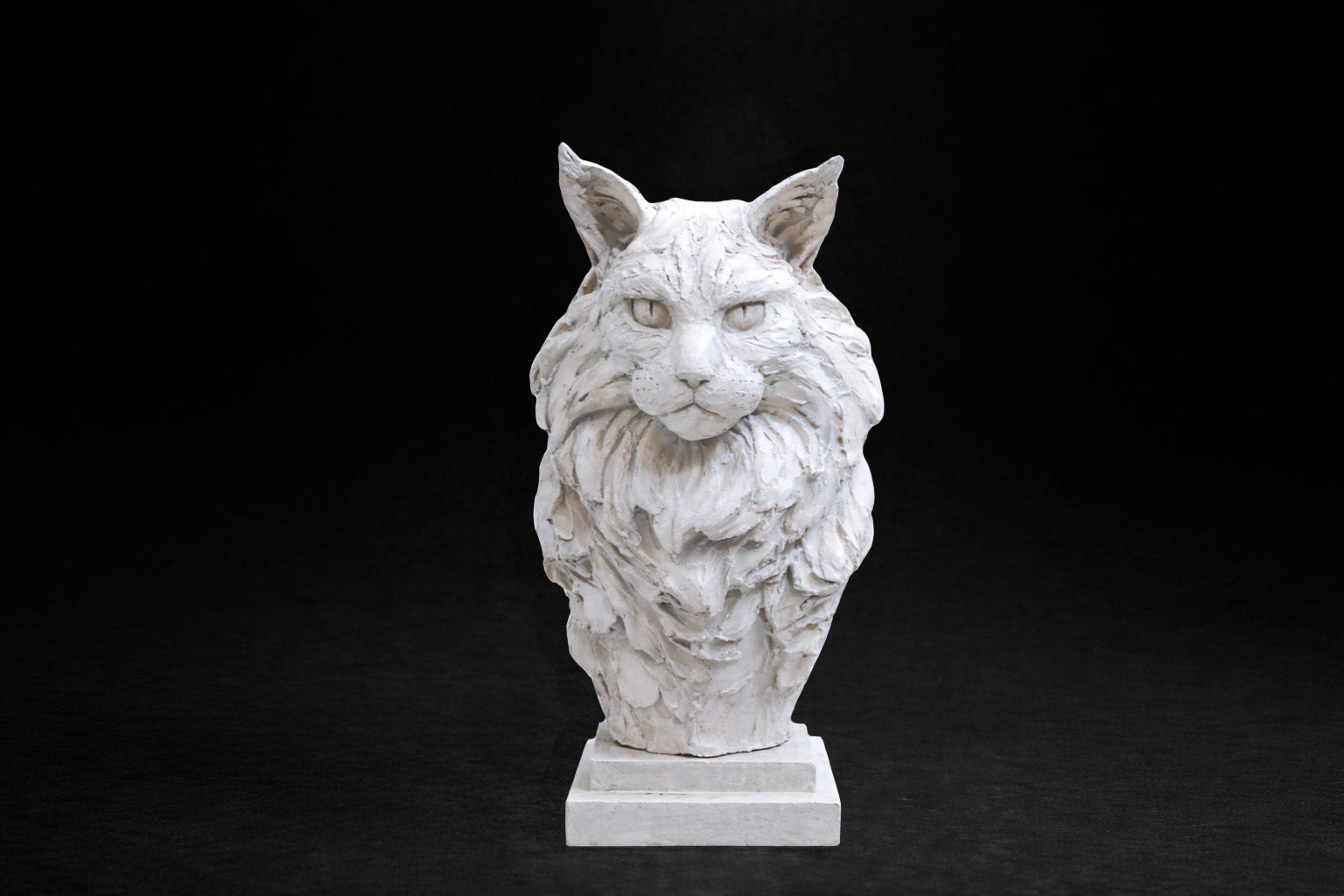 White plaster portrait bust of a Maine Coon cat with a full ruff and tufted ears on a stepped square base.