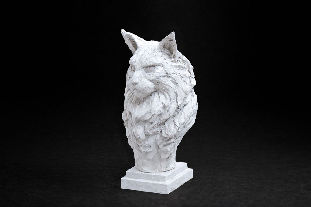 White plaster portrait bust of a Maine Coon cat with a full ruff and tufted ears on a stepped square base.
