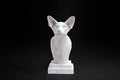 White plaster portrait bust of an Oriental cat with large upright ears and a slender neck on a stepped square base
