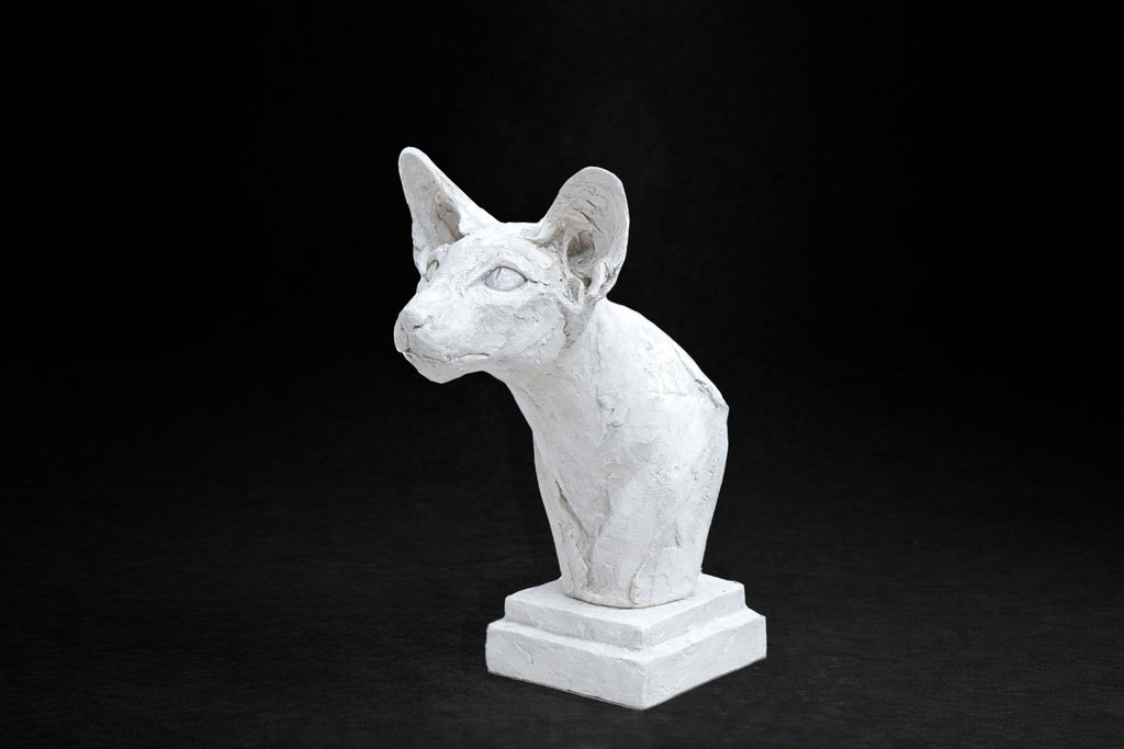White plaster portrait bust of an Oriental cat with large upright ears and a slender neck on a stepped square base