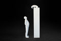 White plaster sculpture of a man standing beside a tall rectangular plinth, looking up at a dachshund peering over the edge.