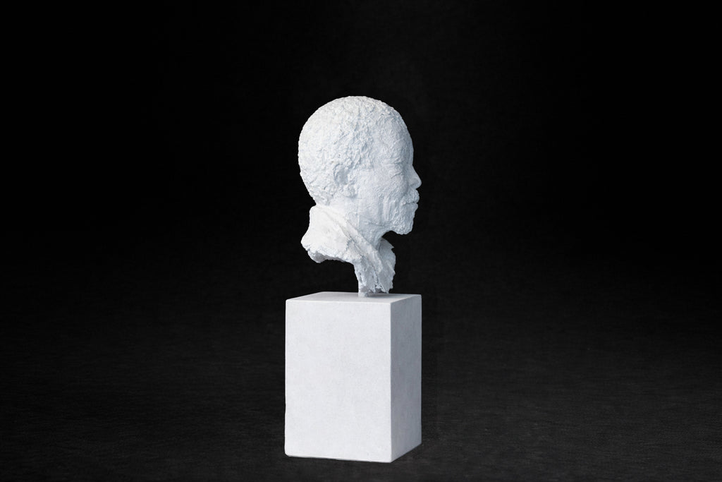  White plaster portrait bust of an elderly man on a square plinth.