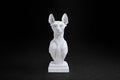 White plaster portrait bust of a Sphinx cat on a stepped square plinth.