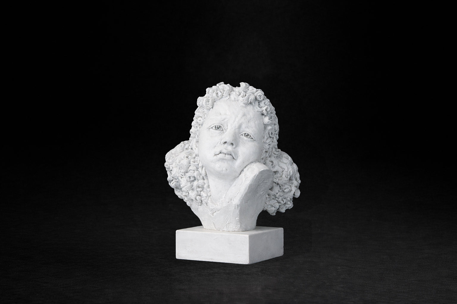 White plaster portrait bust of a young girl with an anguished expression.