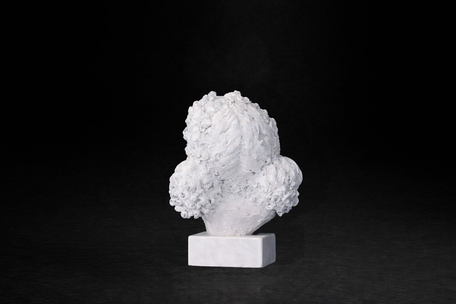 White plaster portrait bust of a young girl with an anguished expression.